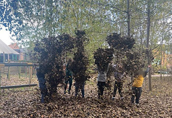 Primary school pupils playing in forest